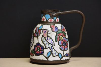 un vase avec un oiseau posé sur une table