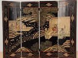 un paravent noir et doré orné d'une peinture