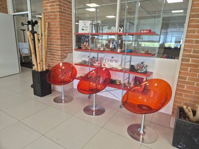 three chairs that are sitting in front of a book shelf