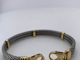 a cable bracelet with two gold clasps on a white surface