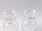 two clear glass vases sitting on a white surface