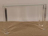 une photo d'une console en verre transparent posée sur un sol recouvert de moquette