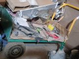 a cart full of items sitting on the floor of a garage