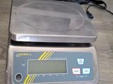 a digital scale sitting on the floor next to a charger