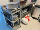 une cuisine équipée d'un micro-ondes, d'un lave-vaisselle et d'autres ustensiles posés sur le plan de travail