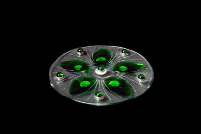 un gros plan d'un objet en verre vert sur fond noir