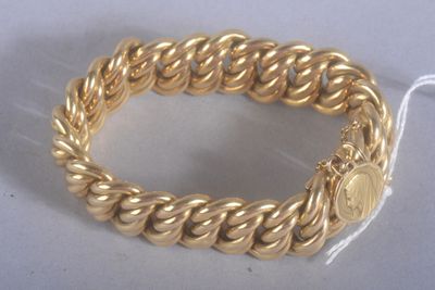 une image d'un gros plan d'un bracelet en or sur une surface blanche