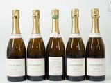 six bouteilles de vin sont alignées sur une surface blanche