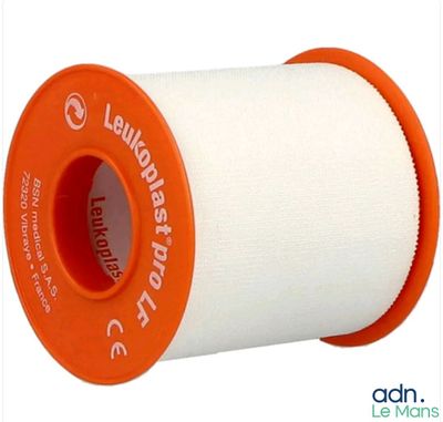une bobine de fil blanc avec un fil orange enroulé dessus