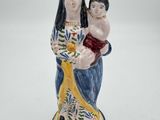figurine représentant une femme tenant un enfant dans ses bras et portant une couronne sur la tête