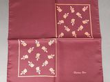 two red handkerchiefs with yellow flowers on them sitting on a table