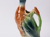 un canard en céramique posé sur un vase