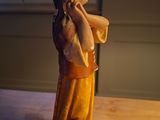 a figurine of a woman holding her head in her hands