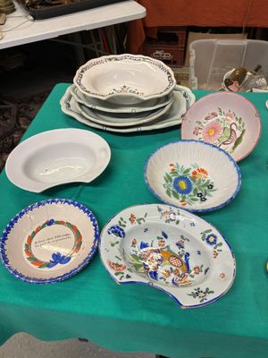 de nombreuses assiettes et bols posés sur une table recouverte d'une nappe verte