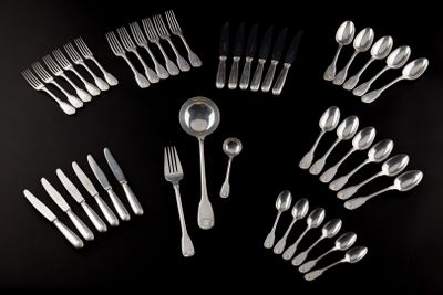 many forks and spoons arranged in a circle on a table