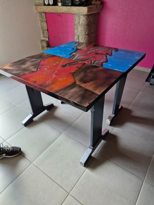 a table with a painting on it and a pair of shoes on the floor