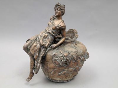statue représentant une femme assise sur un vase, accompagnée d'un chien
