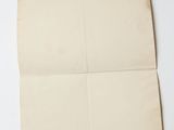an old piece of paper on a white surface with a piece of paper sticking out of it