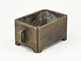 an image of a small bronze pot with a handle on a white background