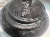 a statue of a man holding a bird on top of a pedestal
