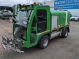 un camion-poubelle vert garé devant un immeuble