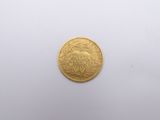 a close up of a gold coin on a white surface