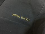 the back of a black jacket with a gold logo on it