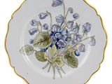 a plate with blue flowers on it on a white background