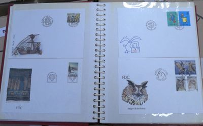 an open book with stamps on it sitting on a table