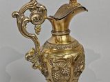 gold plated vase with a handle and a handle on a stand