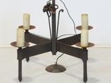 an image of a metal chandelier with four candles on it