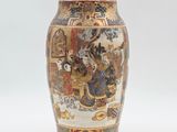 a vase with a painting on it sitting on a table