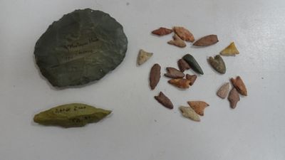 un caillou, une feuille et quelques autres objets posés sur une table