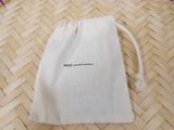 a small white bag with a drawstring on the floor