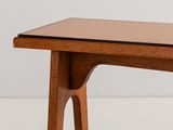 a close up of a wooden table with a glass top on a white surface