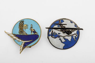 two lapel pins with a picture of a plane flying over the earth