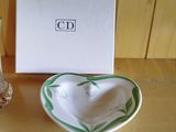 a small heart shaped bowl and a glass on a table