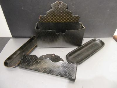 a metal box that has a knife, comb, and other items on it