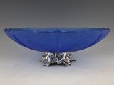 a close up of a blue glass bowl on a metal stand