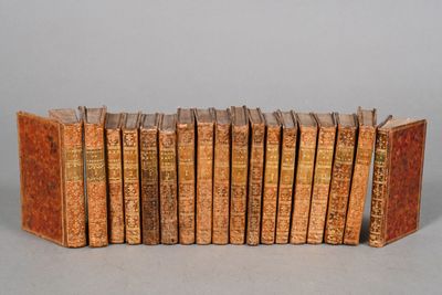 several old books are lined up in a row on a table