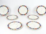six plates with colorful designs are arranged on a white surface