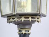 a close up of a lamp post with a clock on it