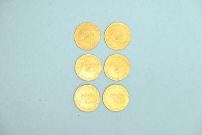 four gold coins are arranged in a row on a blue surface