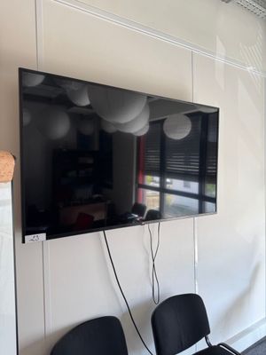 a flat screen tv mounted on the wall above two chairs