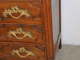 a wooden chest of drawers with gold handles on it