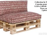 a couch made out of wooden pallets with a red and white cover