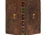 un vieux livre à la couverture brune et à la bordure dorée
