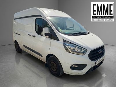 La camionnette blanche est garée dans une grande pièce.