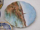 a plate with a painting on it sitting on a table