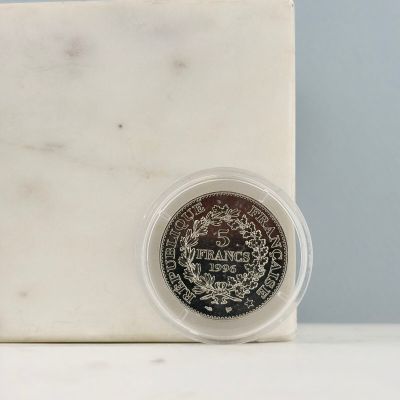 une pièce d'argent posée sur un bloc de marbre